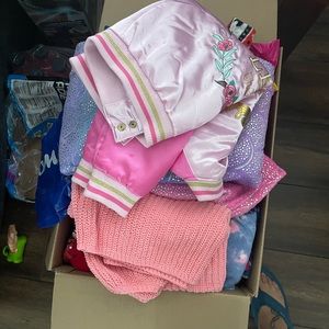 Some brand new girl clothes mixed in with old clothes.